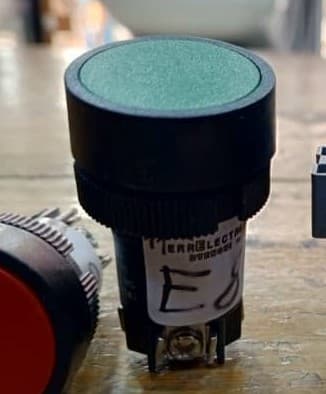 Botón pulsador industrial, color verde, saliente y momentáneo